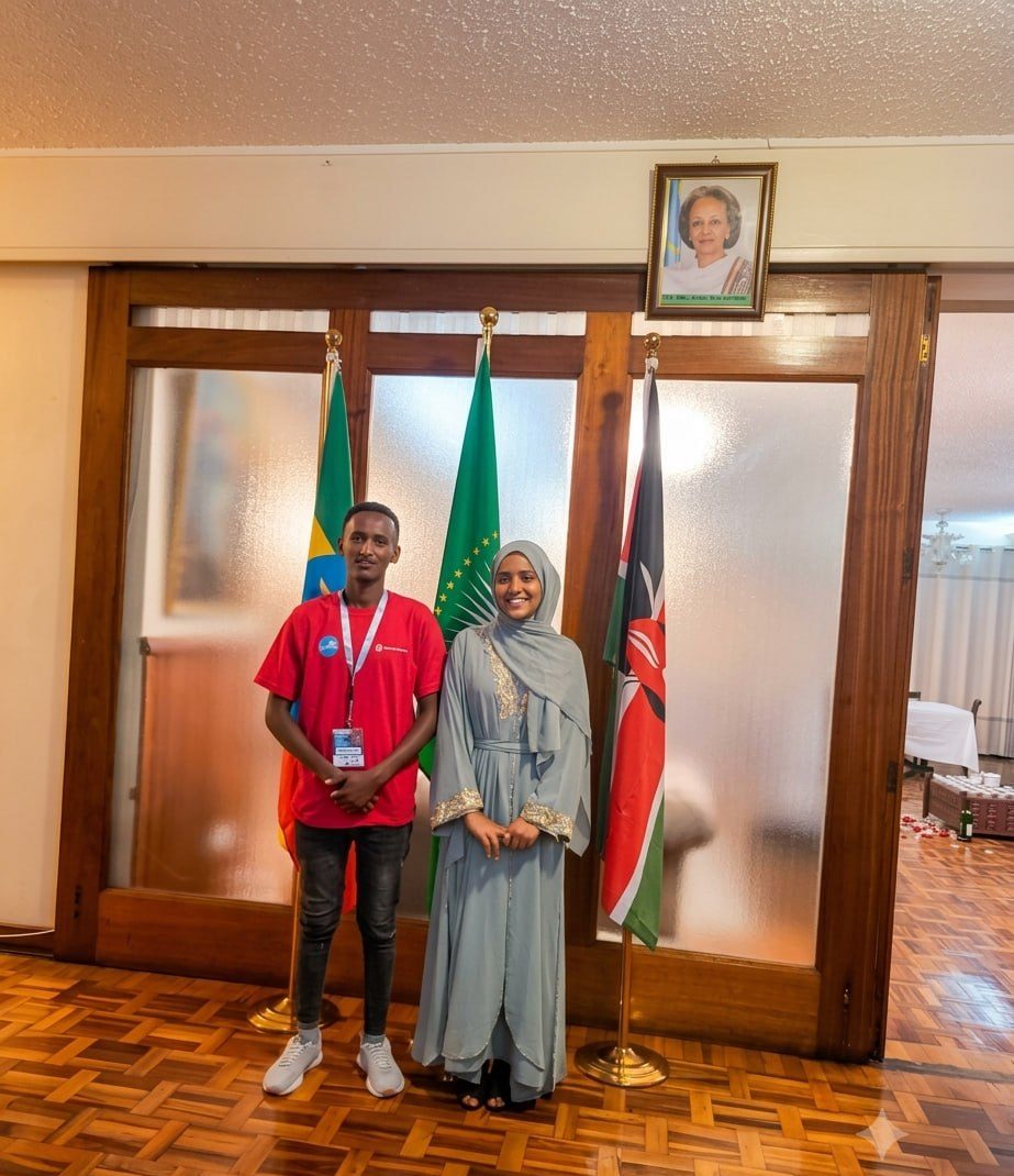 Two youth representatives beside the Ethiopian, African Union and Kenyan flags